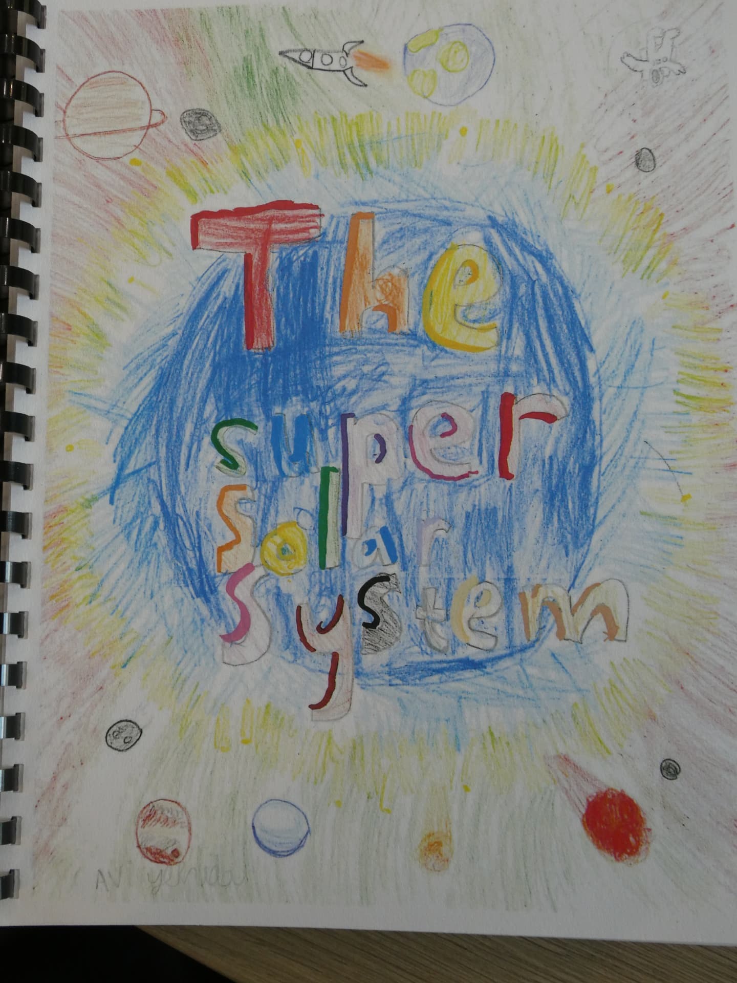 A student's hand-drawn solar system project in a sketchbook
